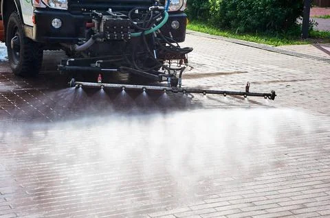 A special machine washes city paths and roads with water Stock Photos