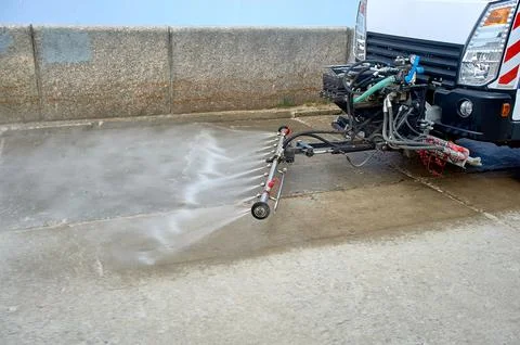 A special machine washes city paths and roads with water Stock Photos