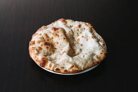 Special naan bread served on a white plate - dark background Foto stock