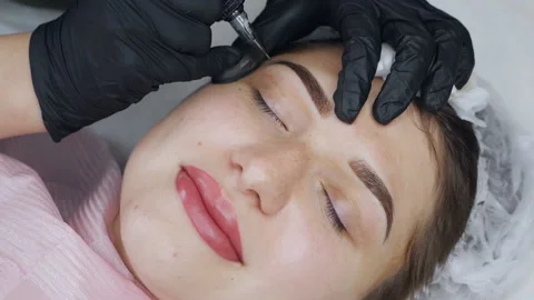 A special needle tattoo machine makes permanent makeup correction of a young 스톡 동영상 166119802