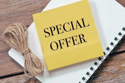 SPECIAL OFFER written on memo note over wooden background. Stock Photos