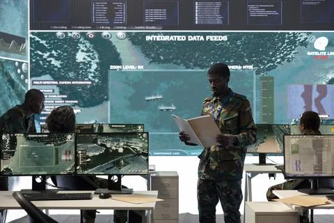 Special operations engineer reading new mission case file brief in control room Stock Photos