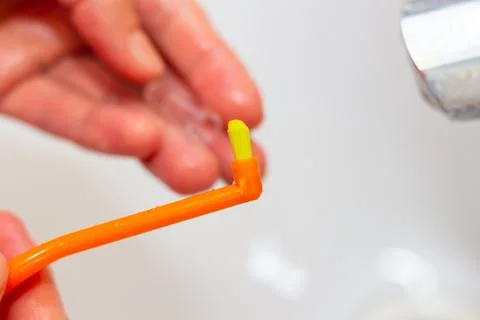 Special toothbrush under the running water in bathroom Stock Photos