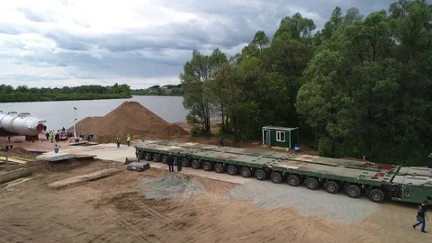 Special transportation platform on wheels, drives up to a barge to transport Stock Footage 124245147