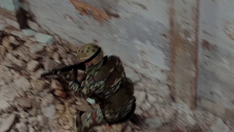 A special unit soldier in camouflage with a weapon moves through the building Stock Footage 126027656