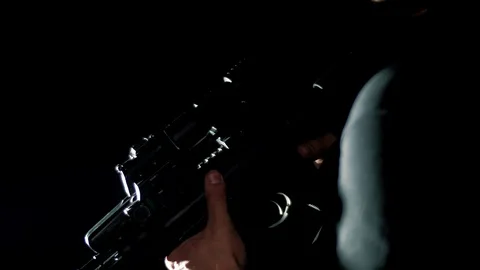 Special unit soldier throws a rifle into a combat position on a black background Stock Footage 128122492