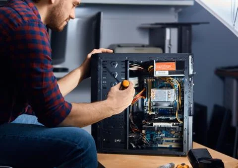 Specialised computer repair technician testing an old system unit Stock Photos