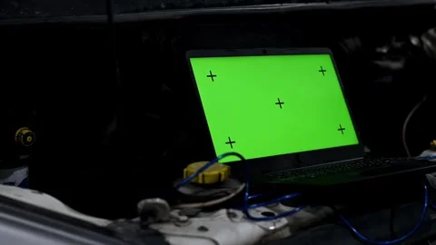 A specialist auto mechanic uses a computer laptop to diagnose and inspect a car Stock Footage 259563076