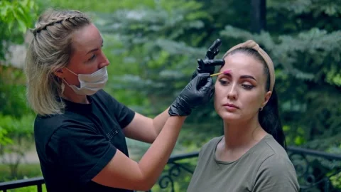 A specialist with a brush smooths the eyebrows on the model Video stock 202010062