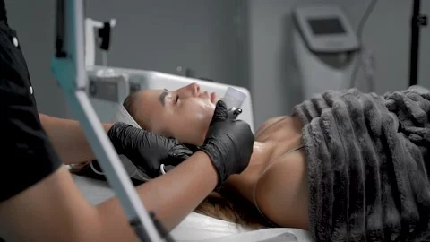 The specialist cleans the face of a lady with the help of the oxygen procedure Stock Footage 228568036
