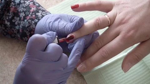 Specialist covers the nail of client by red LED Uv Gel Nail Polish. Close up Stock Footage 74110194