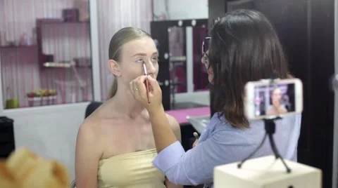 Specialist doing makeup for model. Gentle make-up for the young girl. Stock Footage 67319386