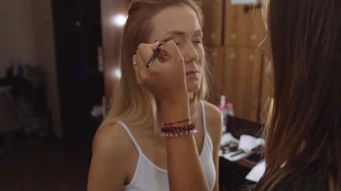 Specialist doing makeup for model. Gentle make-up for the young girl. Closup Stock Footage 81047335