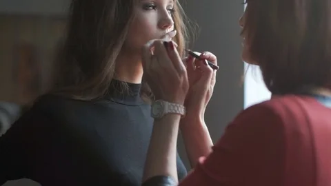 Specialist doing makeup for model. Lip gloss application. Stock Footage 74124556