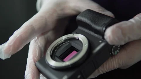 Specialist engineer checking photographic mirrorless camera sensor at mainten Stock Footage 319883371