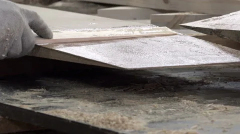 Specialist with a flat stick evenly distributes liquid adhesive composition of Vídeo Stock 62011627