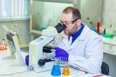 Specialist looking through microscope performing scientific research in a Stock Photos