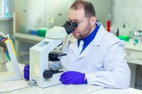 Specialist looking through microscope performing scientific research in a Stock Photos