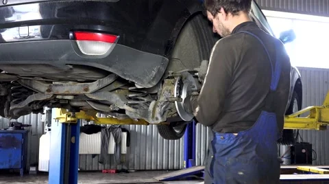 Specialist mechanic repairing customer car brake system Stock Footage