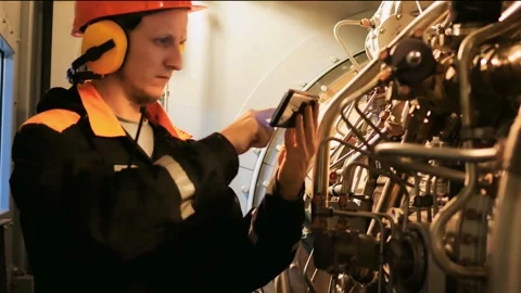 Specialist monitors aircraft engine performance using smartphone, verifying Stock Footage 287295625