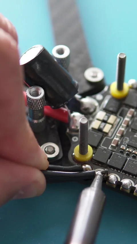 A specialist performs soldering on an FPV drone. Vertical video frame. Stock Footage 318342120