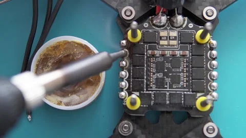 A specialist performs soldering on an FPV drone. Stock Footage 318342123