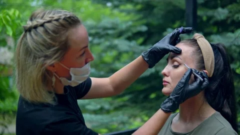 The specialist plucks his eyebrows on the model before staining. Stock Footage 202010103