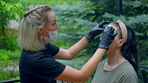 The specialist plucks his eyebrows on the model before staining. Stock Footage 202010138