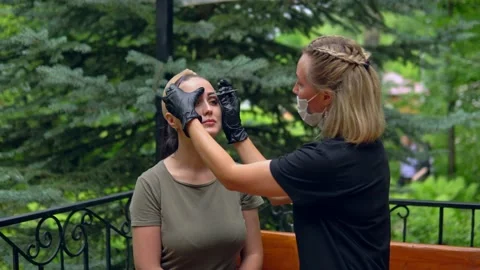 The specialist plucks his eyebrows on the model before staining. Stock Footage 202010276
