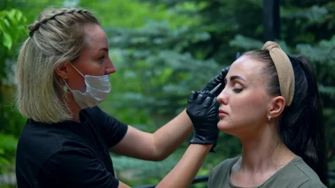 The specialist plucks his eyebrows on the model before staining. Stock Footage 202010525
