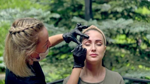 The specialist plucks his eyebrows on the model before staining. Stock Footage 202010612