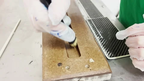A specialist in protective gloves covers the baking form of a carbon product Stock Footage 168256026