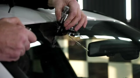 Specialist repairs crack in windshield on location without replacement glass. Stock Footage 315380229