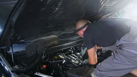 Specialist repairs faults in engine compartment of car Stock Footage 317630693