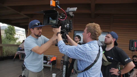 Specialist setups professional video camera at scene Stock Footage 231294081