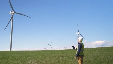Specialist standing near wind mill and checking information on t Stock Footage 111067006