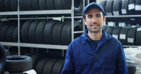 Specialist tire fitting in the car service, checks the tire and rubber tread for Stock Footage
