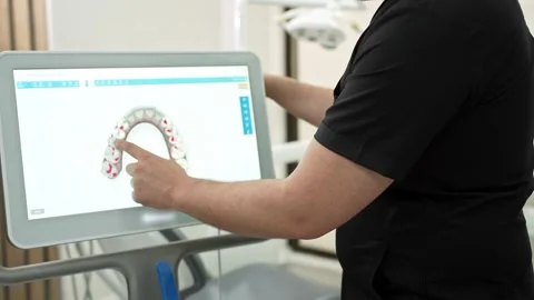 Specialist in uniform pointing to jaws models on computer screen using Stock Footage 250116691