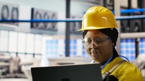 Specialist using laptop to conduct routine inspections in industry 4.0 plant 库存照片