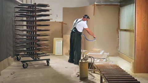 Specialist using a spray gun sprays adhesive composition Stock Footage 98265495