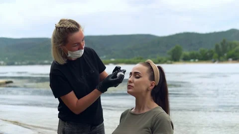 The specialist washes off the paint from the eyebrow of the model Stock Footage 202010570