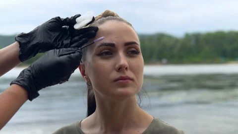The specialist washes off the paint from the eyebrow of the model Video stock 202010723