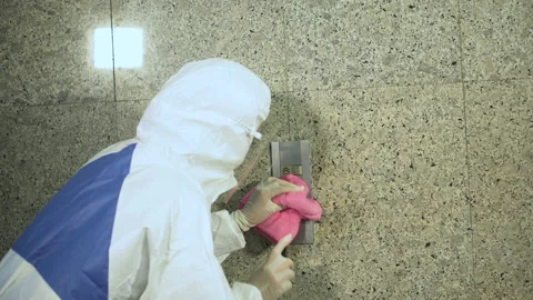 Specialist wearing ppe suit using alcohol sanitizer spray to cleaning an elev Stock Footage 140125022