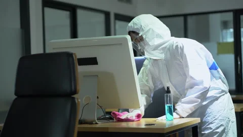 Specialist wearing ppe suit using alcohol sanitizer spray to cleaning compute Stock Footage 158866274