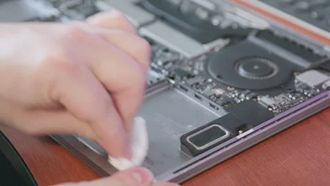 A specialist wipes the inside surface of the laptop case with a white napkin to Stock Footage 335389097