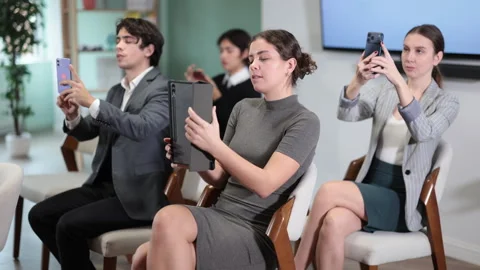 Specialists take pictures of the presentation on mobile phone and tab during Stock Footage 332639877