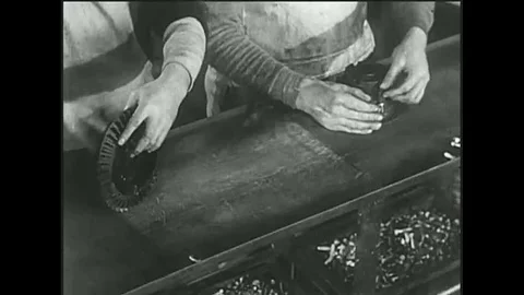 Specialists work on subassemblies and a conveyor belt is used as Model T Stock Footage 118650892
