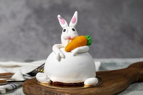 Specially designed bunny shaped cake. Cake on gray wooden table and Easter Bu Stock Photos