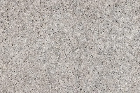 A speckled concrete watt with tiny pebbles and granular texture. Seamless b.. Stock Photos