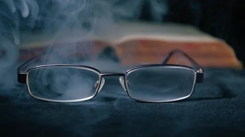 Spectacle glasses covered with mist book in background Stock Footage 302840352